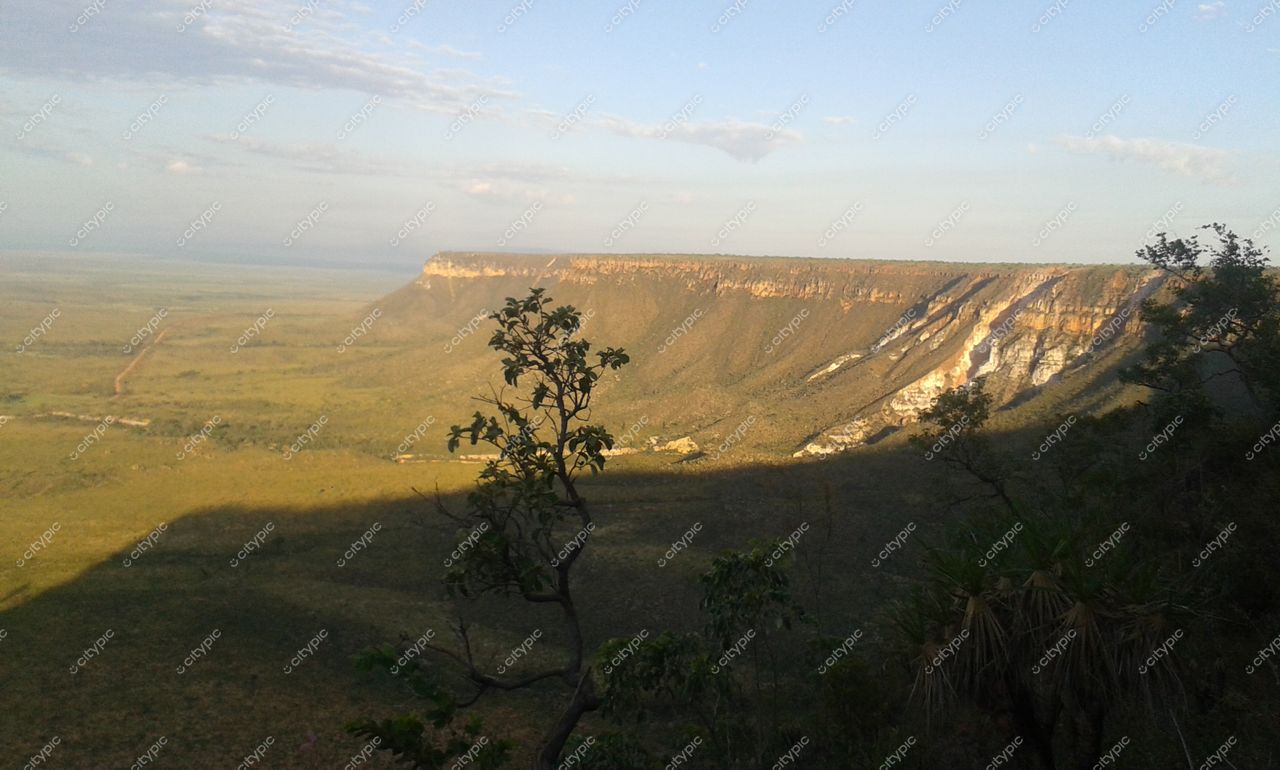 Jalapão, Tocantins, paisagem do cerrado com morro ao fundo e estrada serpenteando sob luz suave do final da tarde