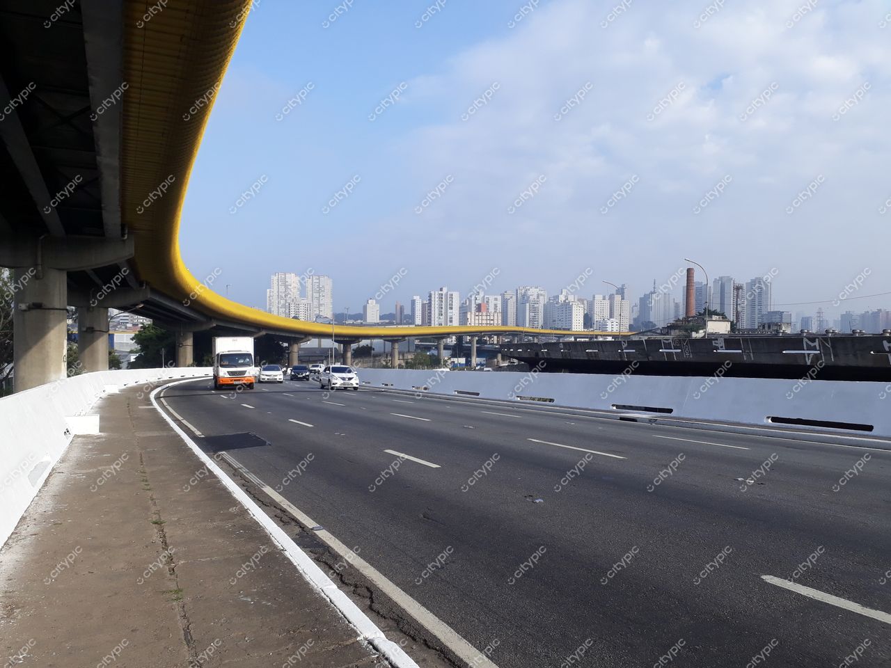 São Paulo, São Paulo, vista diurna de via com elevado amarelo e tráfego intenso de veículos e ônibus
