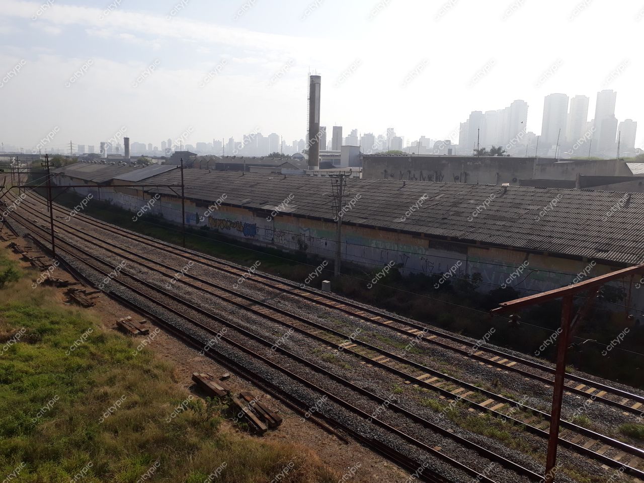 São Paulo, São Paulo, vista urbana com trilhos de trem e edificações industriais sob céu nublado pela manhã