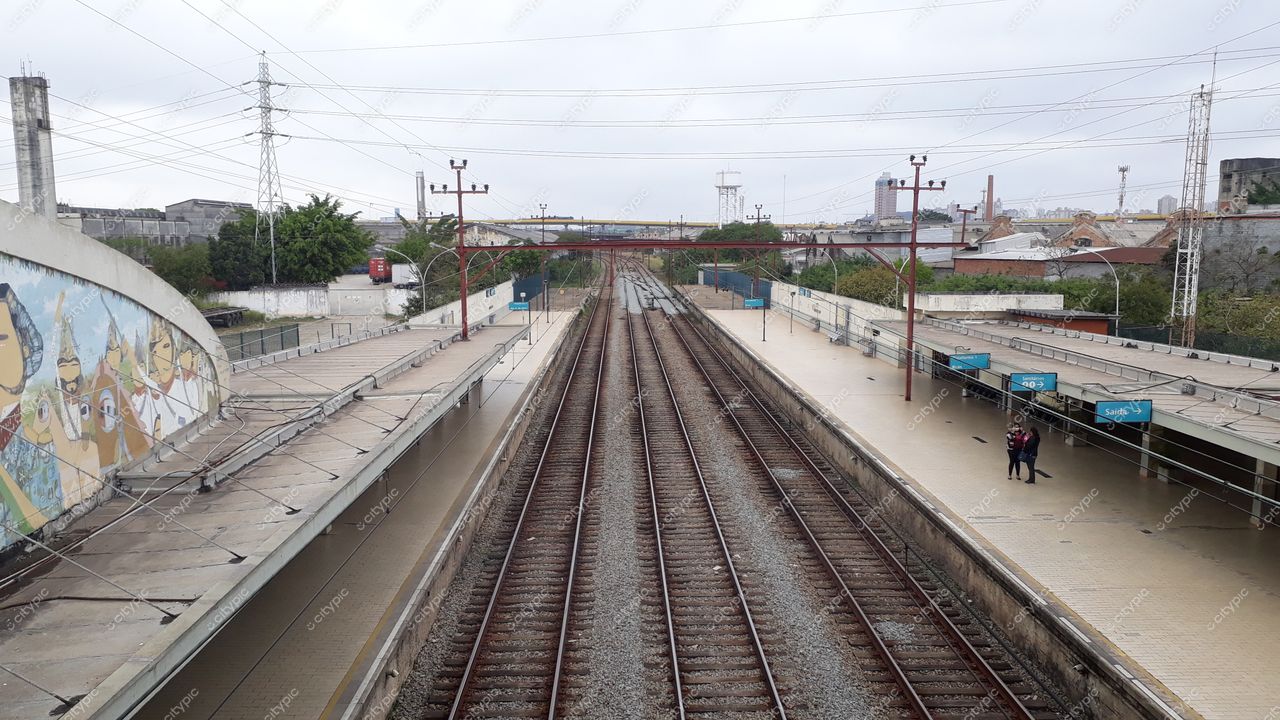 São Paulo, São Paulo, estação ferroviária com mural colorido e trilhos sob céu nublado em luz suave diurna