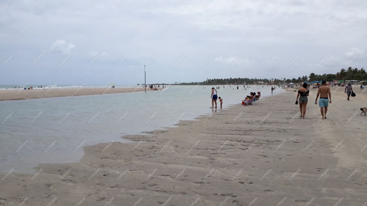 Paripueira, Alagoas com céu nublado e iluminação suave, praia com areia clara e vegetação tropical ao fundo