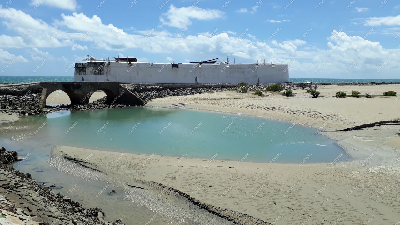 Natal, Rio Grande do Norte com estrutura histórica branca sobre elevação e canal de água doce refletindo vegetação