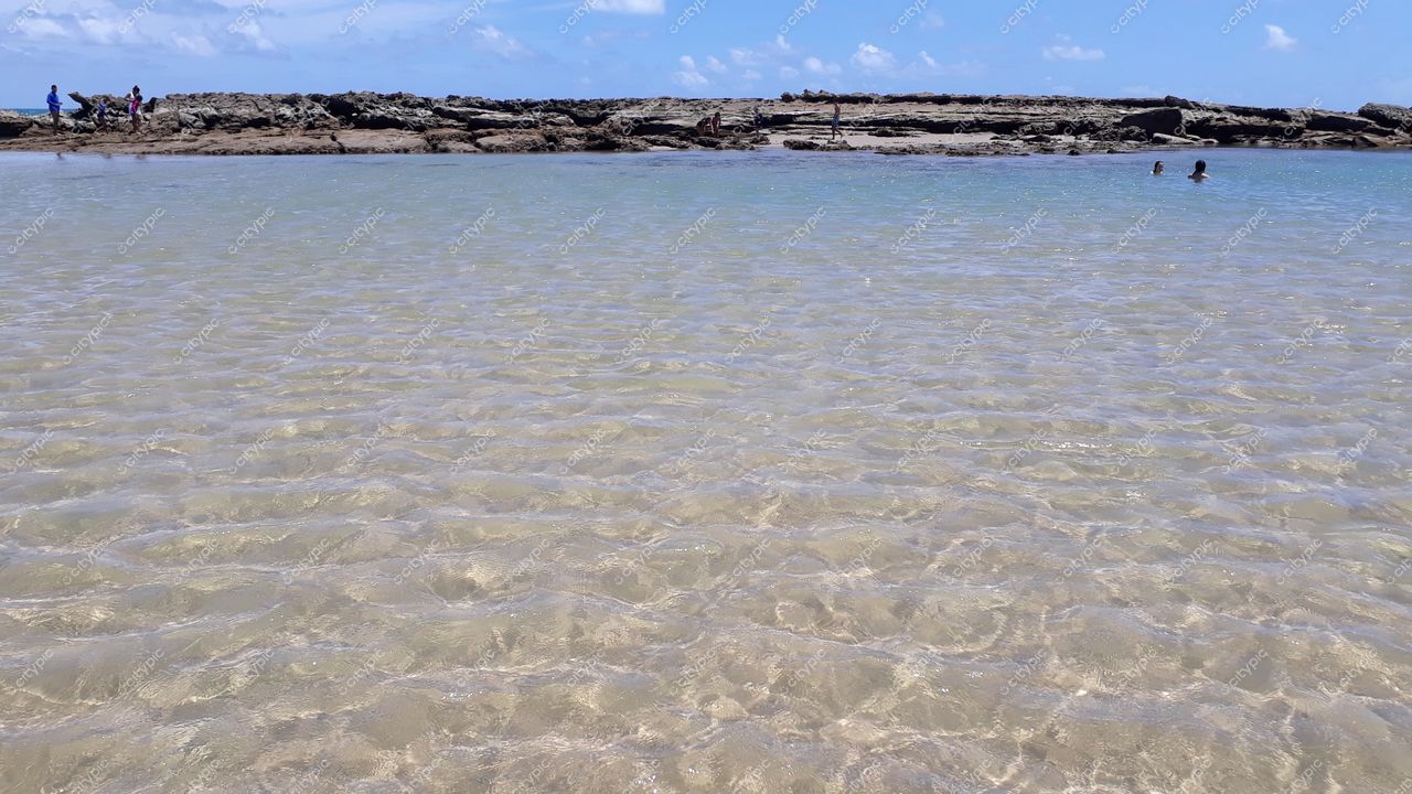 Natal, Rio Grande do Norte com praia de águas claras e rasas sob céu limpo em dia ensolarado