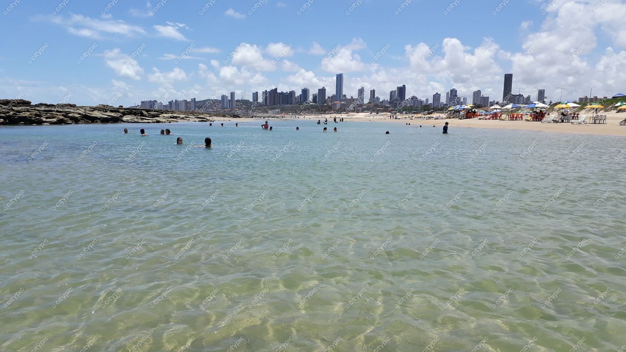 Natal, Rio Grande do Norte, vista da praia com arranha-céus ao fundo e pessoas se refrescando no mar
