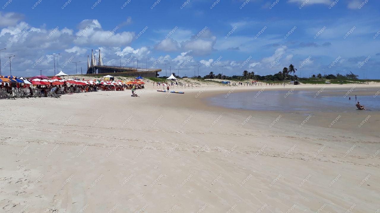 Natal, Rio Grande do Norte com barracas coloridas na praia e construção moderna ao fundo em dia ensolarado