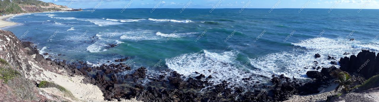 Tibau do Sul, Rio Grande do Norte vista panorâmica da costa com rochas escuras e vegetação sob céu nublado