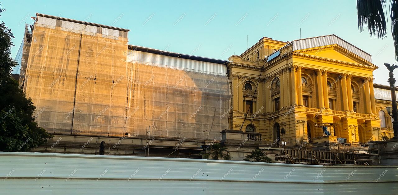 São Paulo, São Paulo, fachada de edifício histórico amarelo com tela de proteção e iluminação suave do final da tarde