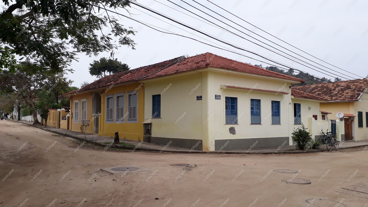Ilha de Paquetá, Rio de Janeiro, esquina tranquila com casas coloniais amarelas e telhados vermelhos em dia nublado
