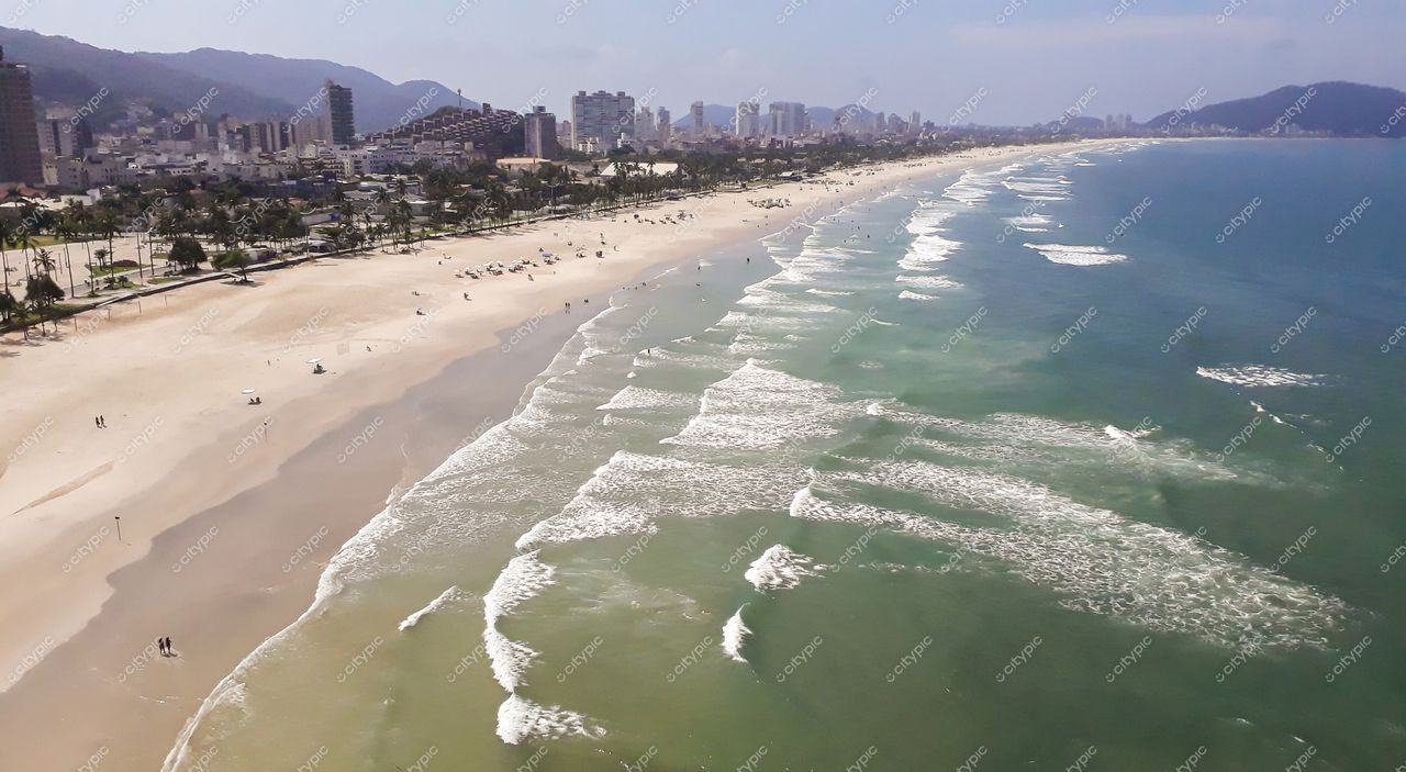 Guarujá, São Paulo vista panorâmica da praia em dia ensolarado com vegetação e montanhas ao fundo