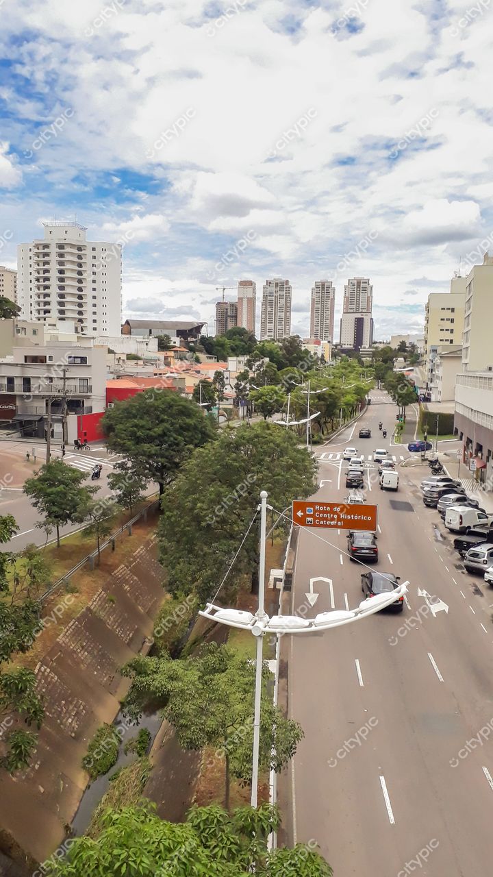 Jundiaí, São Paulo vista urbana em dia nublado com tráfego e vegetação ao longo de córrego e edifícios variados