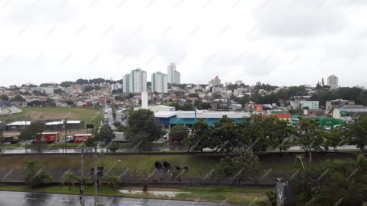 Jundiaí, São Paulo vista sob céu nublado com prédios ao fundo e vegetação nas calçadas em destaque