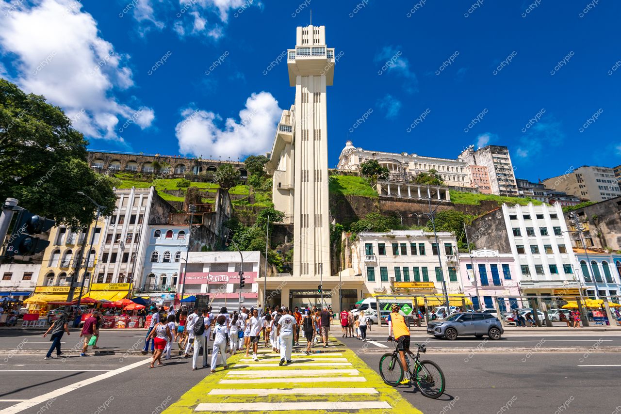 Salvador, Bahia vista de um edifício imponente cercado por vegetação com pedestres e bicicletas em dia ensolarado