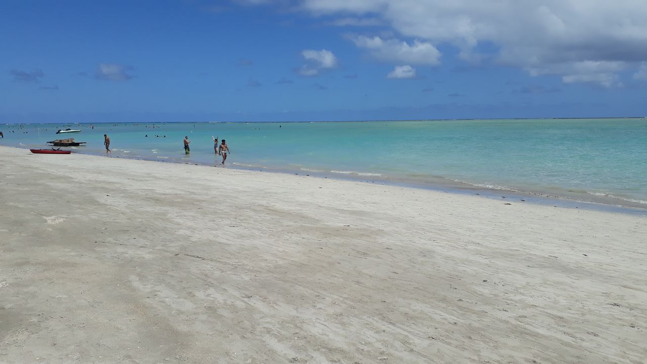 Maragogi, Alagoas com areia clara e fina, mar em tons de azul e verde em dia ensolarado com nuvens