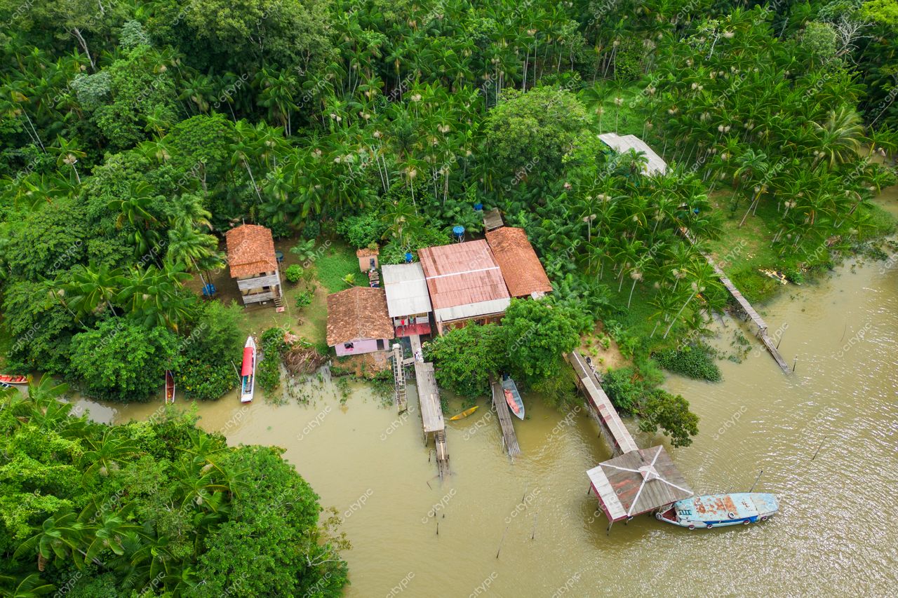 Belém, Pará vista aérea de área residencial com casas de palha e madeira cercadas por vegetação tropical e rio calmo
