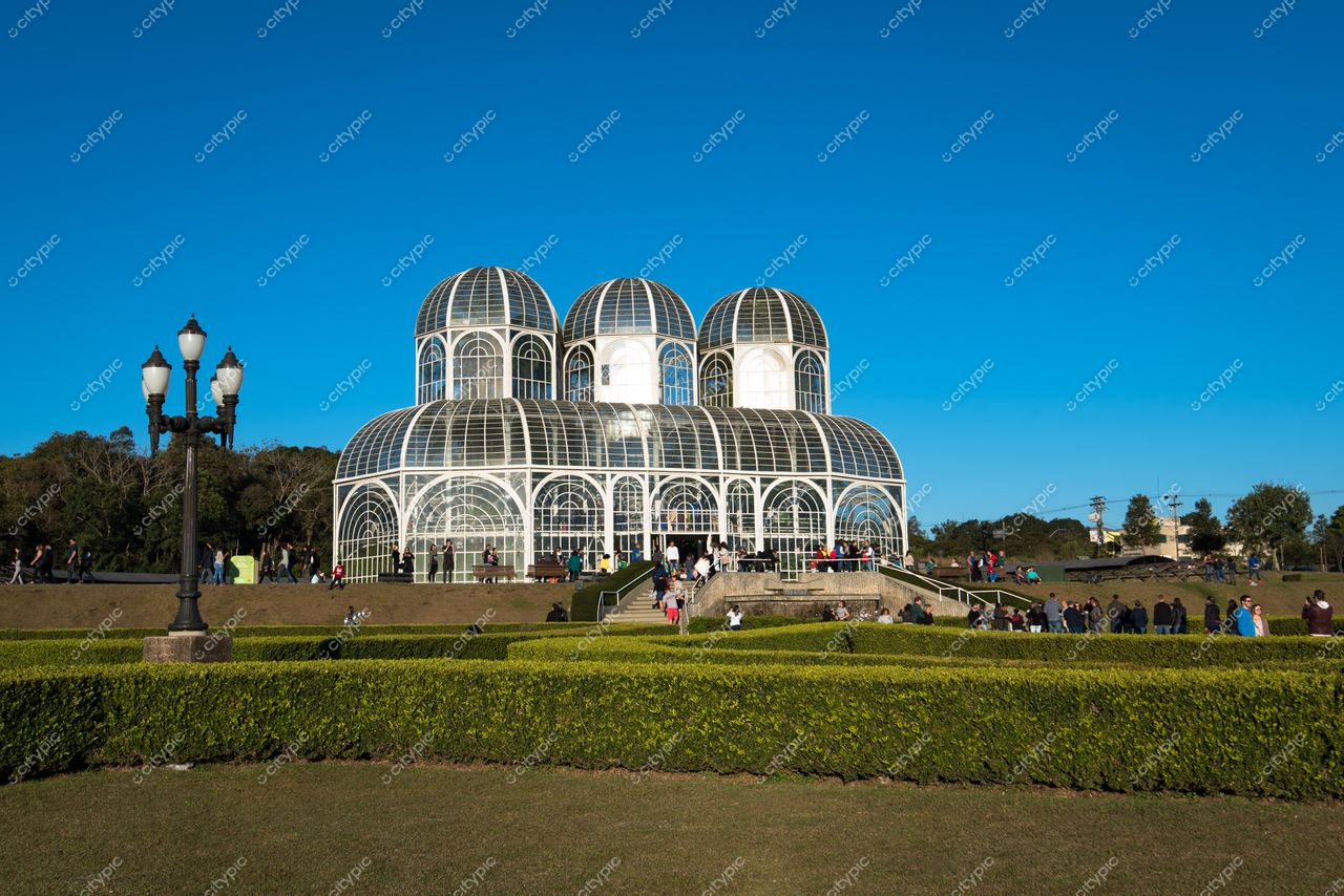 Curitiba, Paraná, Jardim Botânico em dia ensolarado com visitantes e cúpulas de vidro contrastando com a vegetação