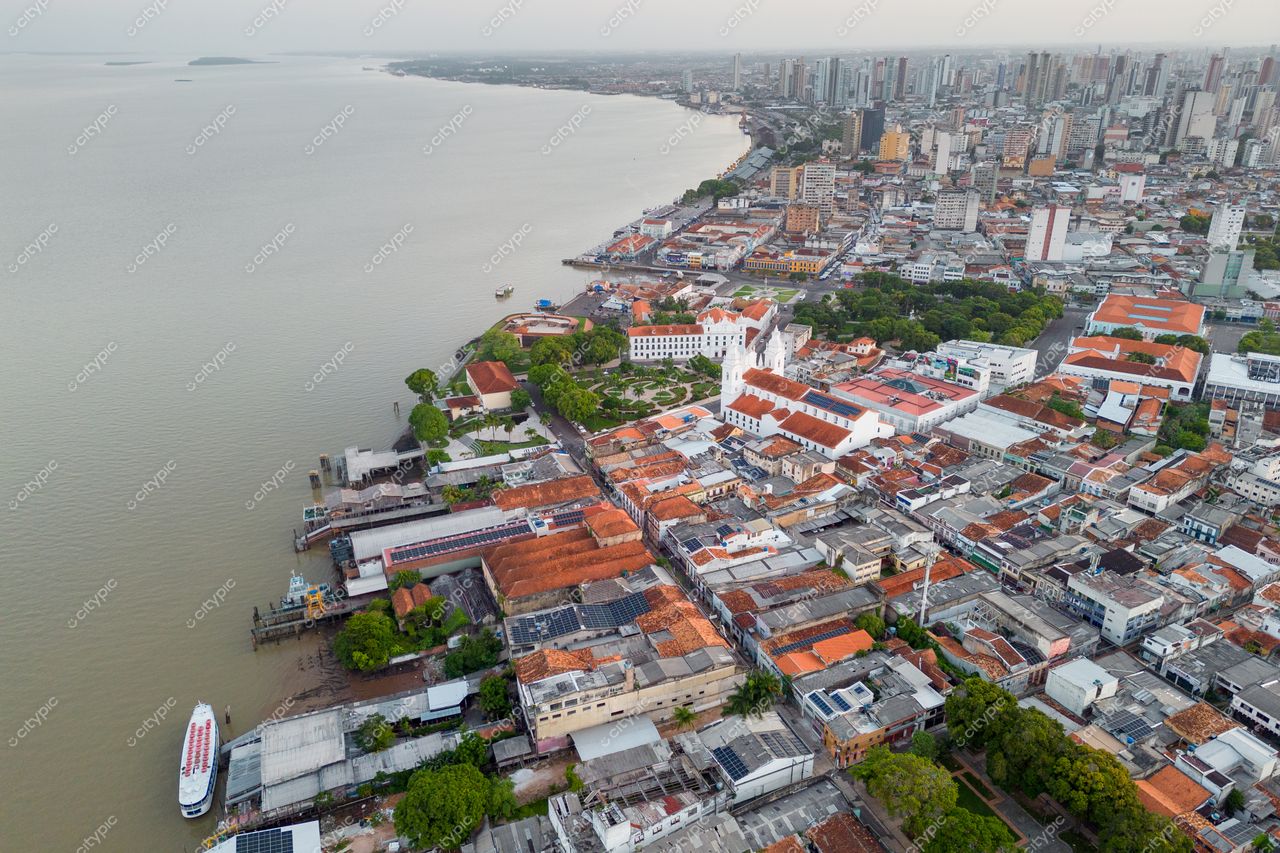 Belém, Pará vista aérea ao entardecer com arquitetura colonial, vegetação nas margens e embarcações no rio Guamá