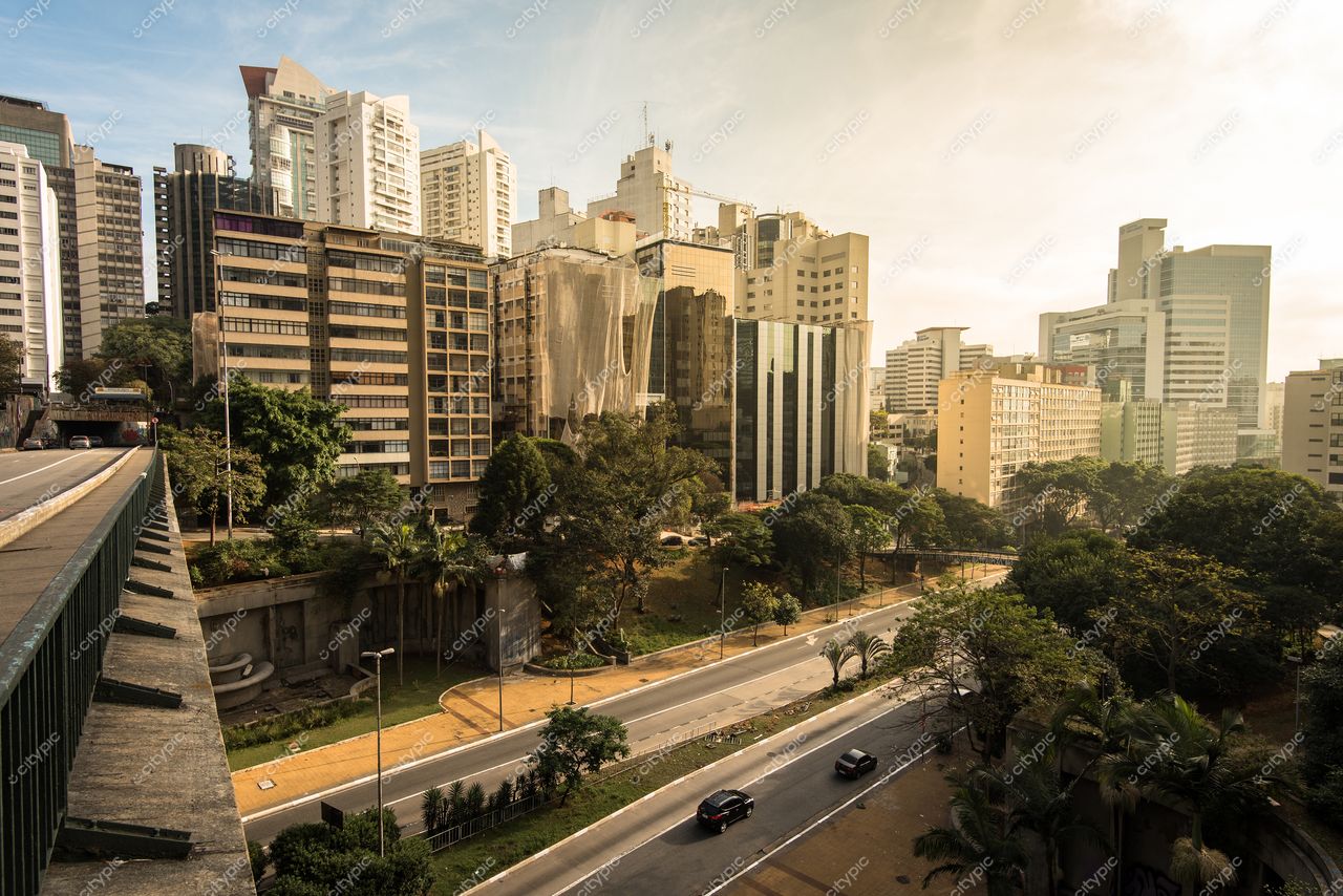 São Paulo, São Paulo, vista urbana com iluminação suave destacando edifícios modernos e áreas verdes ao lado da rua