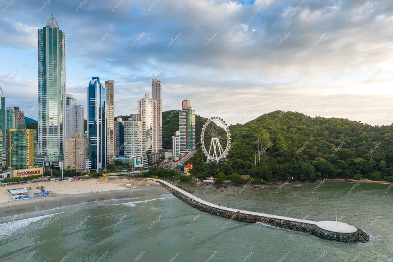 Balneário Camboriú, Santa Catarina com vista panorâmica ao entardecer, arranha-céus, roda-gigante e vegetação ao fundo