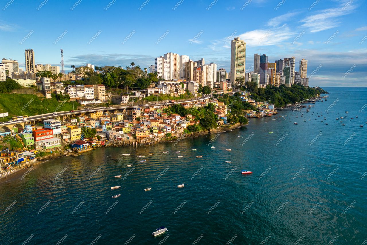 Salvador, Bahia vista de cima com casas coloridas à beira-mar e modernos edifícios sob céu ensolarado