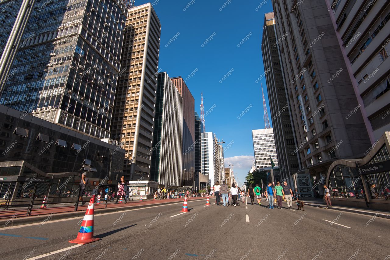 São Paulo, São Paulo, rua ampla com edifícios modernos e cones de trânsito em dia ensolarado e claro