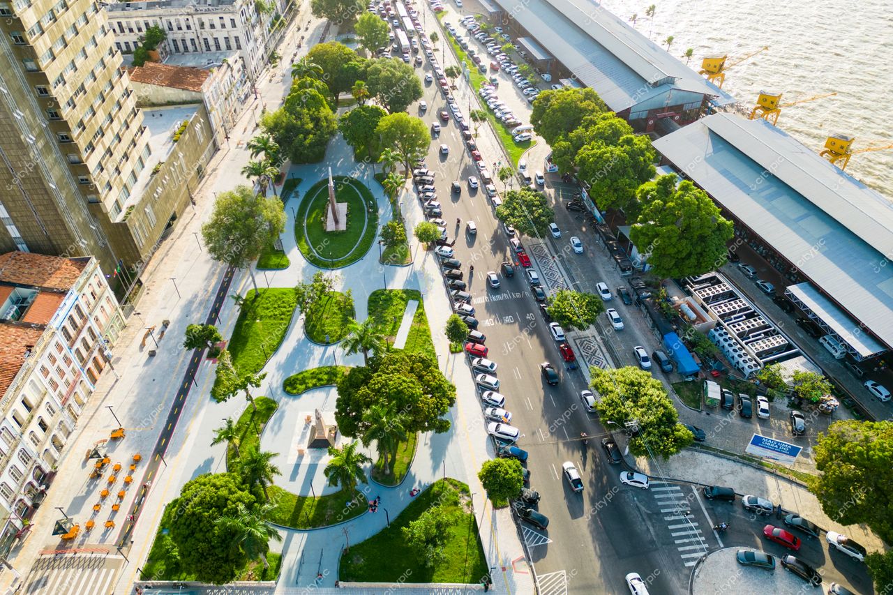 Belém, Pará vista aérea de área urbana com vegetação bem cuidada, ruas movimentadas e reflexo do sol na água