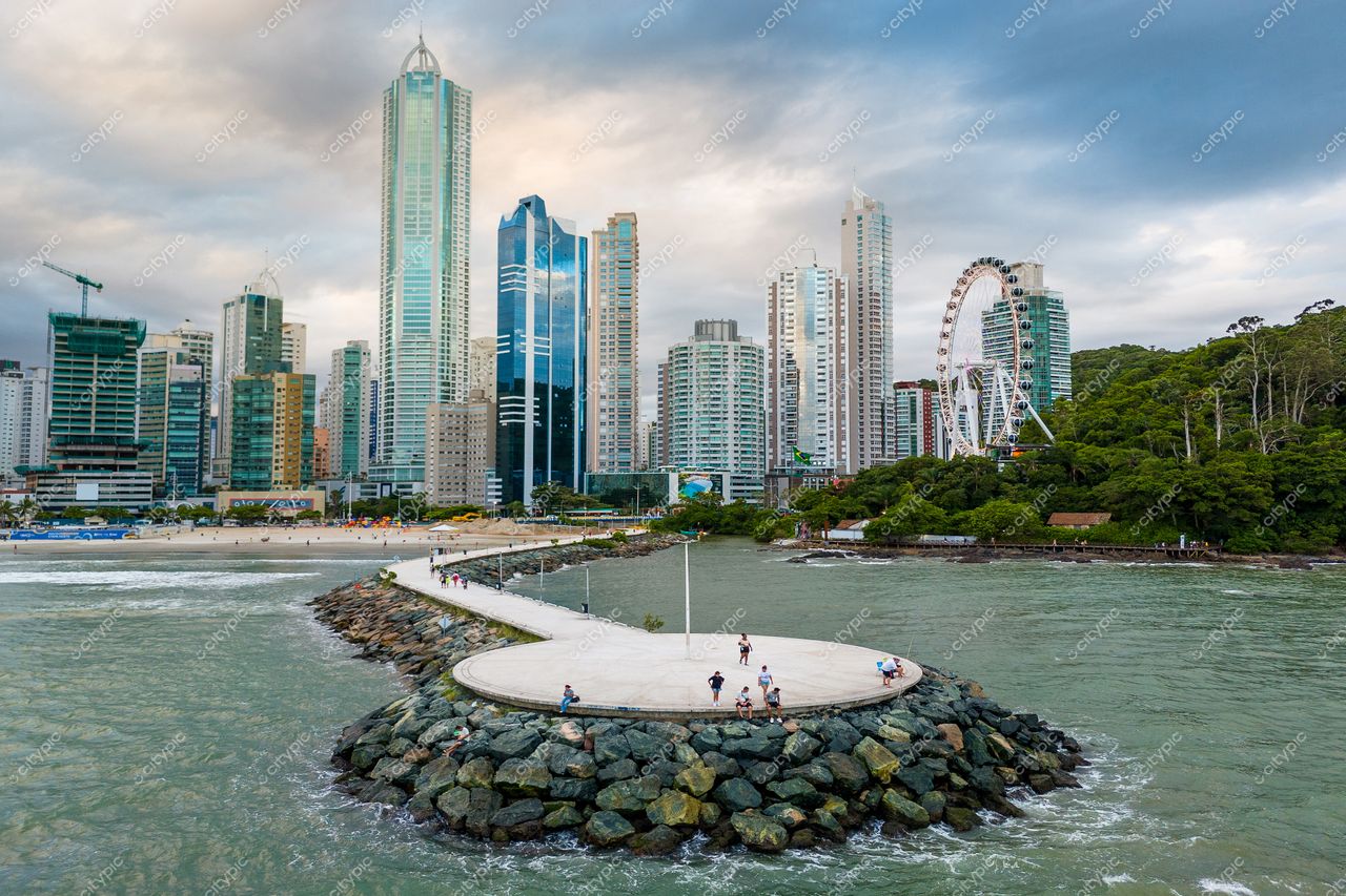 Balneário Camboriú, Santa Catarina, vista panorâmica com arranha-céus e píer ao entardecer sob céu nublado
