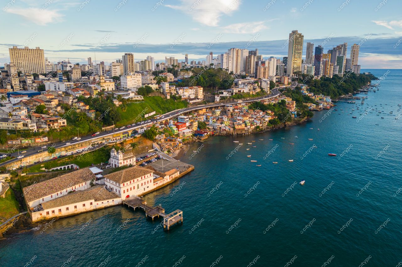 Salvador, Bahia vista aérea da costa com edifícios coloridos e vegetação ao amanhecer refletindo no oceano