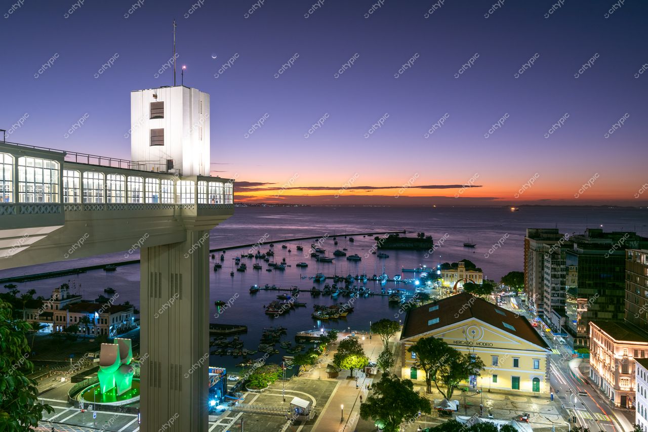Salvador, Bahia, pôr do sol com luz suave iluminando o Elevador Lacerda e barcos na baía ao fundo