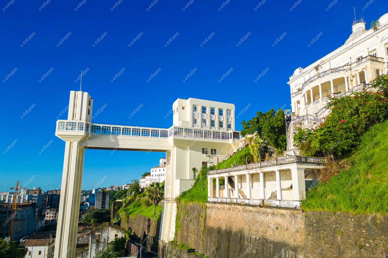 Salvador, Bahia, elevador panorâmico em dia ensolarado com vegetação verde e arquitetura colonial ao fundo
