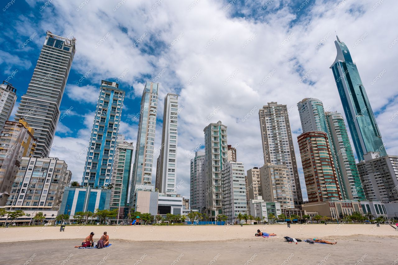Balneário Camboriú, Santa Catarina, orla com arranha-céus modernos sob céu parcialmente nublado e vegetação ao fundo