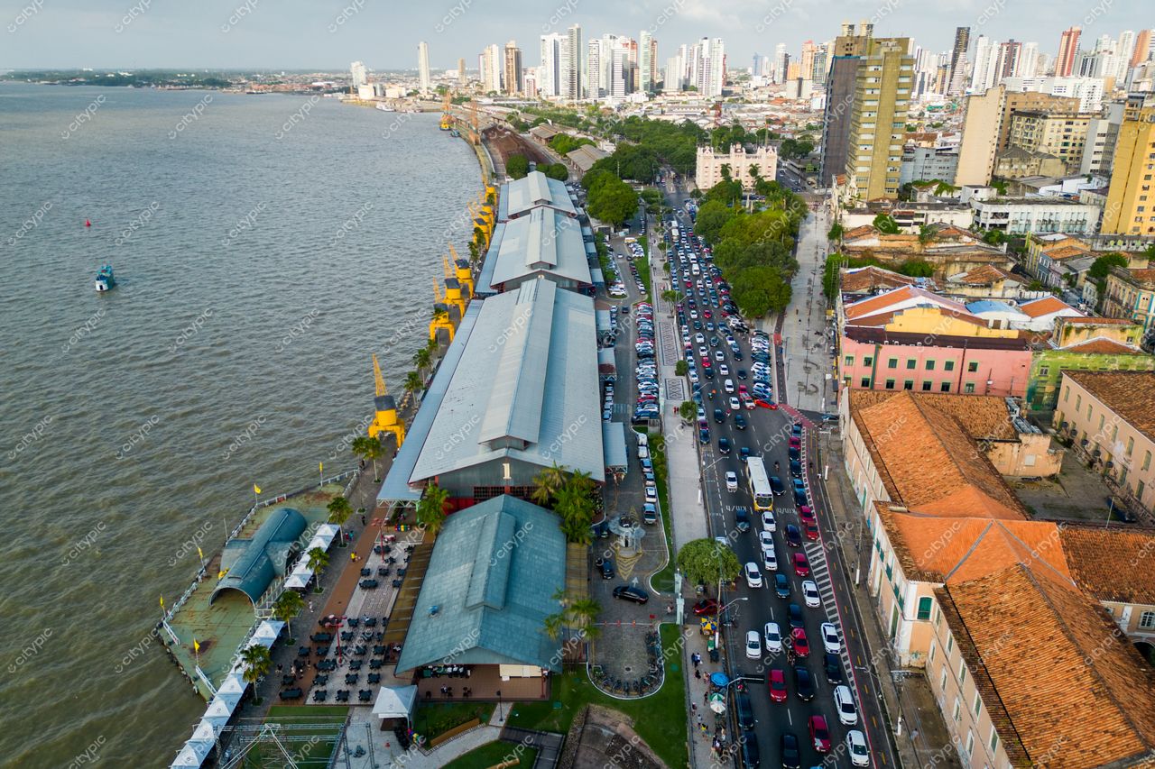Belém, Pará, vista aérea da orla com armazém histórico, vegetação densa e tráfego intenso ao entardecer