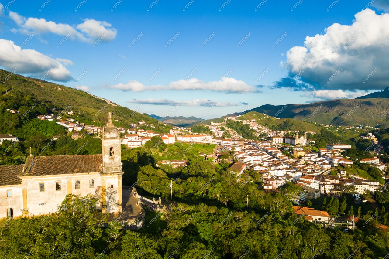 Ouro Preto, Minas Gerais vista panorâmica com arquitetura colonial e vegetação densa em relevo montanhoso sob céu azul