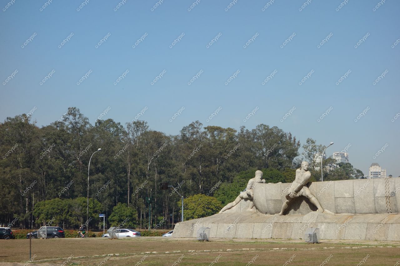Monumento às Bandeiras em São Paulo com céu claro, vegetação ao fundo e tráfego reduzido nas ruas próximas