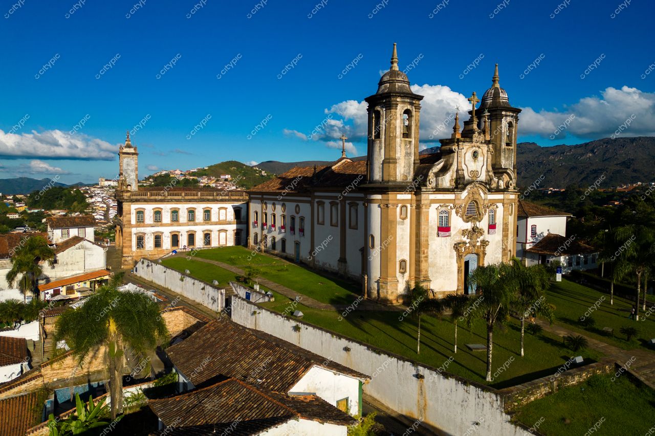 Ouro Preto, Minas Gerais, panorama com edificações coloniais e montanhas sob céu azul em dia ensolarado