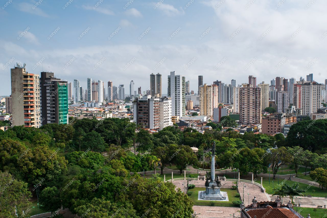 Belém, Pará com vista panorâmica de edifícios altos e parque denso sob céu nublado durante o dia