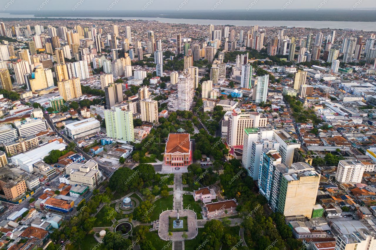 Belém, Pará vista aérea ao entardecer com edifício vermelho cercado por áreas verdes e altos prédios urbanos