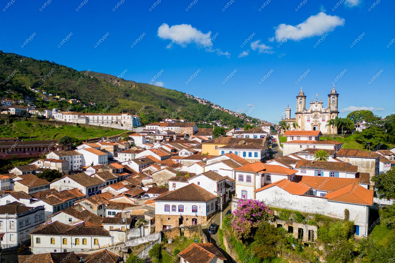 Ouro Preto, Minas Gerais vista panorâmica com casas coloniais e igrejas barrocas sob céu azul em dia ensolarado
