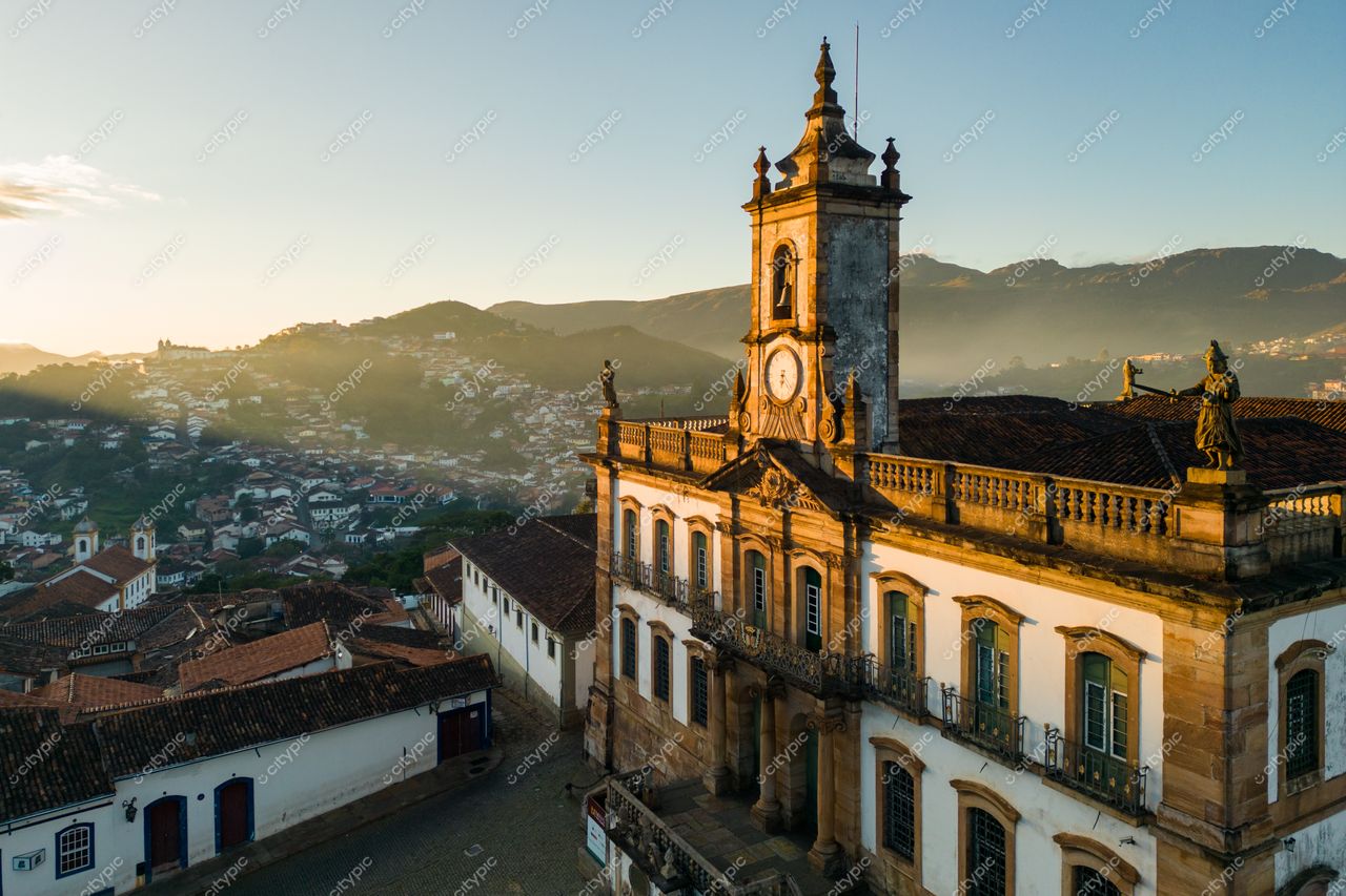 Ouro Preto, Minas Gerais, edifício histórico com torre de relógio ao pôr do sol e montanhas ao fundo
