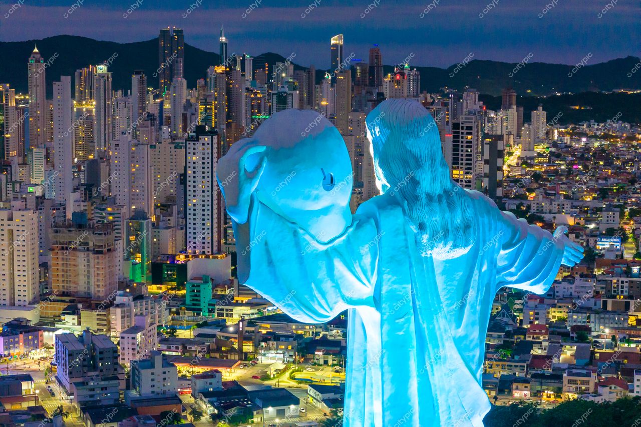 Balneário Camboriú, Santa Catarina vista noturna com Cristo Luz iluminado em azul e modernos edifícios ao fundo