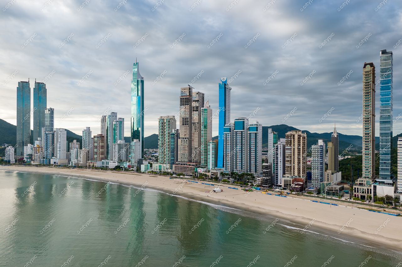 Balneário Camboriú, Santa Catarina, orla em dia nublado com edifícios modernos e colinas verdes ao fundo