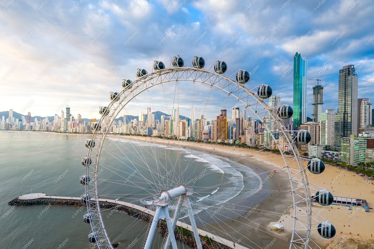 Balneário Camboriú, Santa Catarina, vista panorâmica com roda-gigante ao entardecer e edifícios refletindo no mar calmo