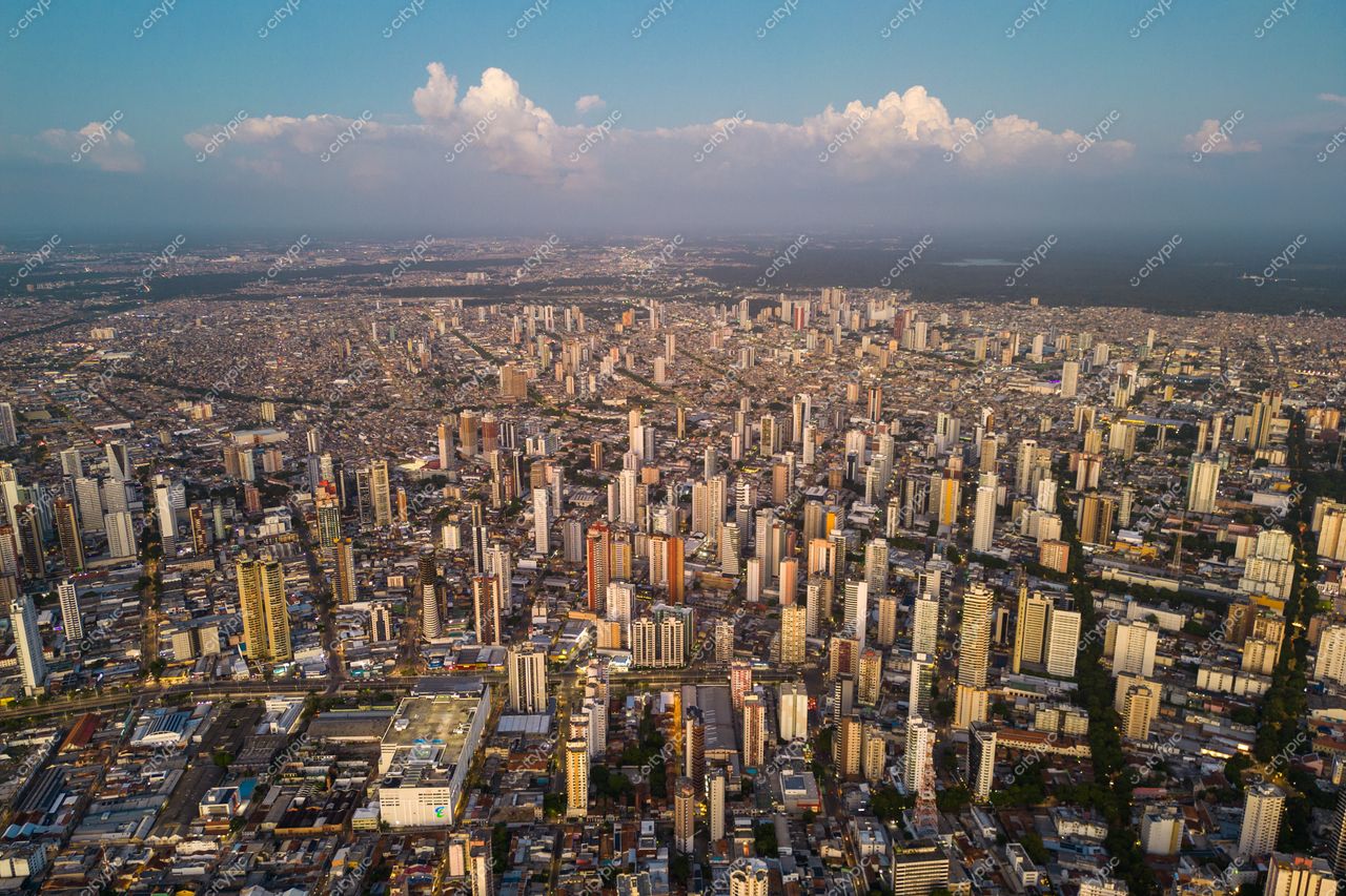 Belém, Pará vista aérea ao entardecer com densa malha urbana e áreas verdes nas bordas da cidade