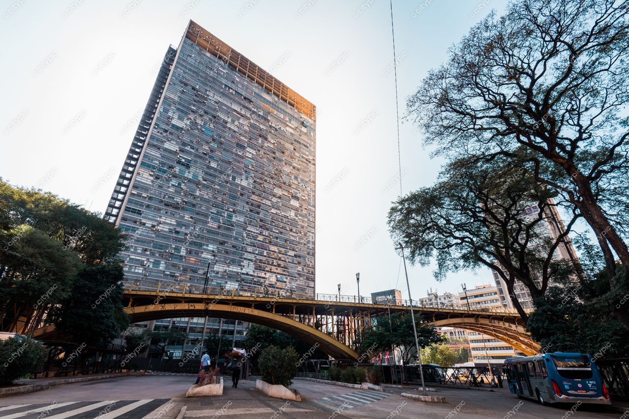 São Paulo, São Paulo, edifício moderno com fachada metálica e ponte amarela em dia ensolarado com vegetação e pessoas