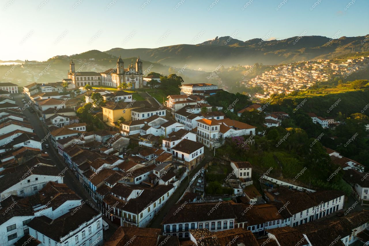 Ouro Preto, Minas Gerais vista aérea ao amanhecer com casas coloniais e relevo montanhoso iluminados suavemente