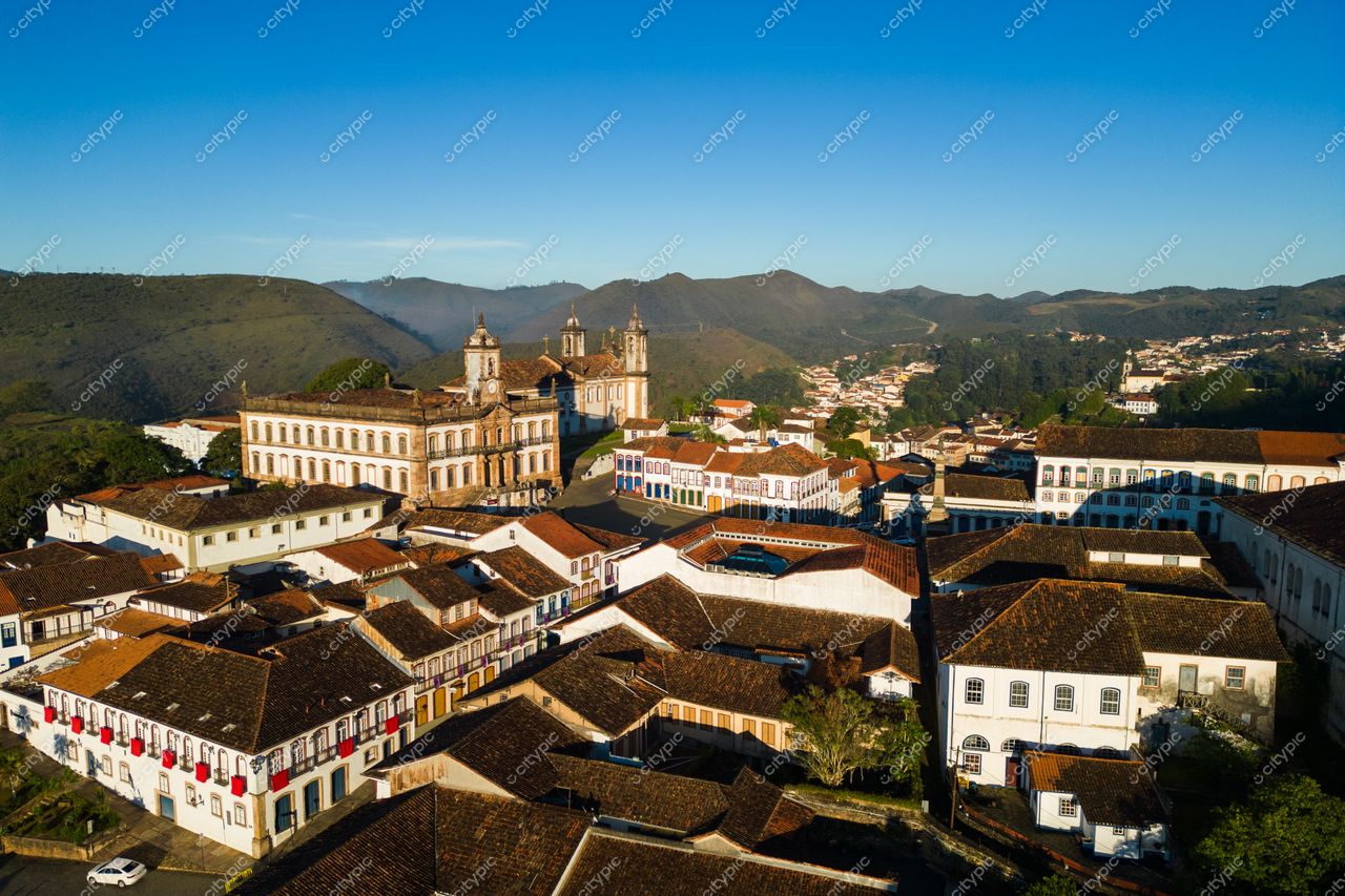 Ouro Preto, Minas Gerais vista aérea com arquitetura colonial e montanhas ao fundo em manhã ensolarada e clara