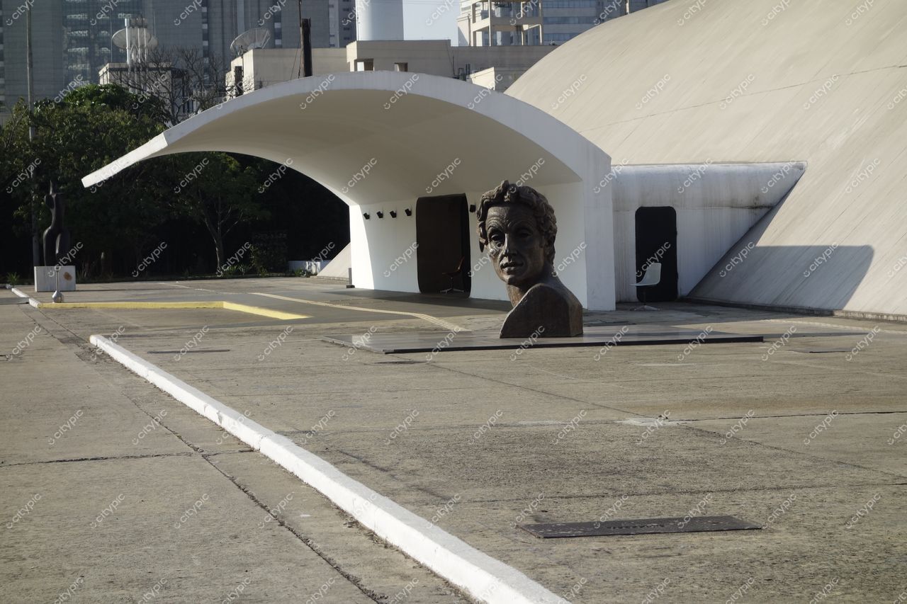 Parque Ibirapuera, em São Paulo, escultura de bronze em destaque com arquitetura moderna e vegetação ao redor