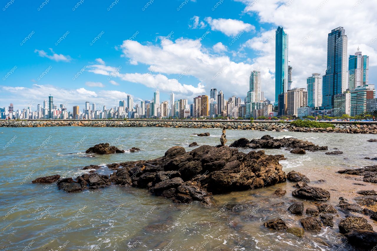 Balneário Camboriú, Santa Catarina com rochas à beira-mar e edifícios altos sob céu parcialmente nublado