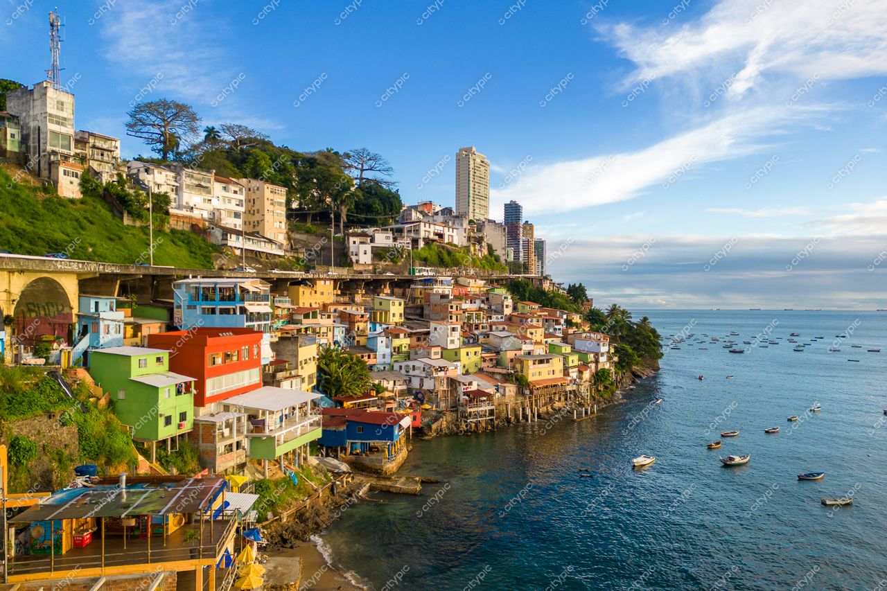 Salvador, Bahia vista panorâmica com casas coloridas na encosta, vegetação tropical e águas azuis ao amanhecer