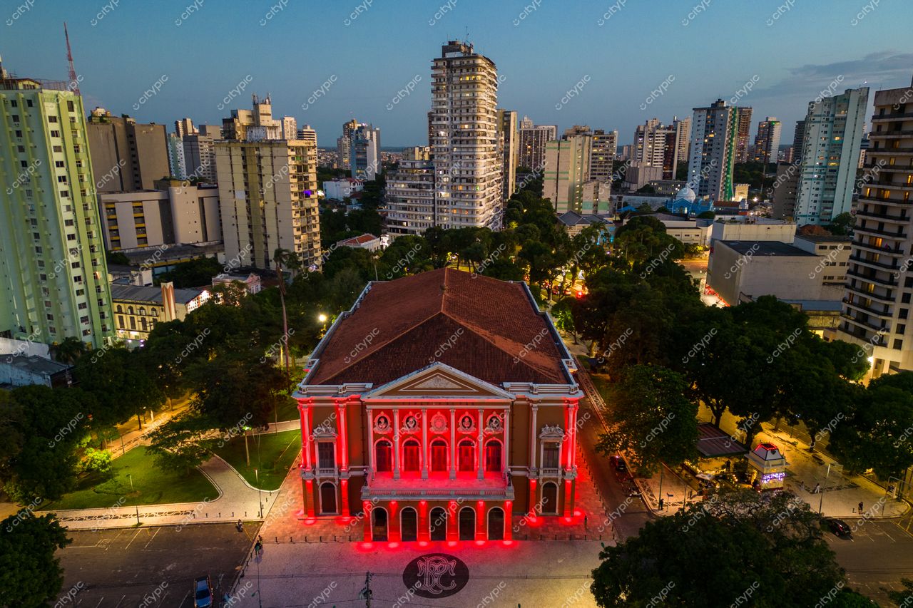 Belém, Pará vista aérea ao entardecer com Theatro da Paz iluminado em vermelho e céu azul e laranja
