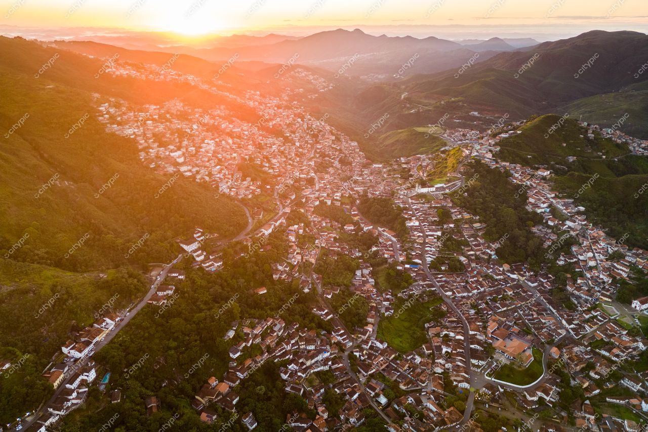 Ouro Preto, Minas Gerais ao amanhecer com luz suave iluminando casas coloniais e montanhas verdes ao fundo